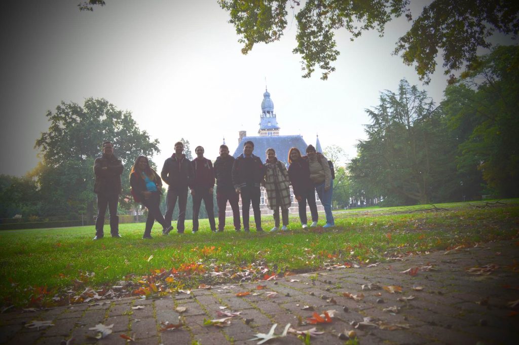 Group picture in the backyard of the castle of Wijchen, with a lot of green grass and trees.