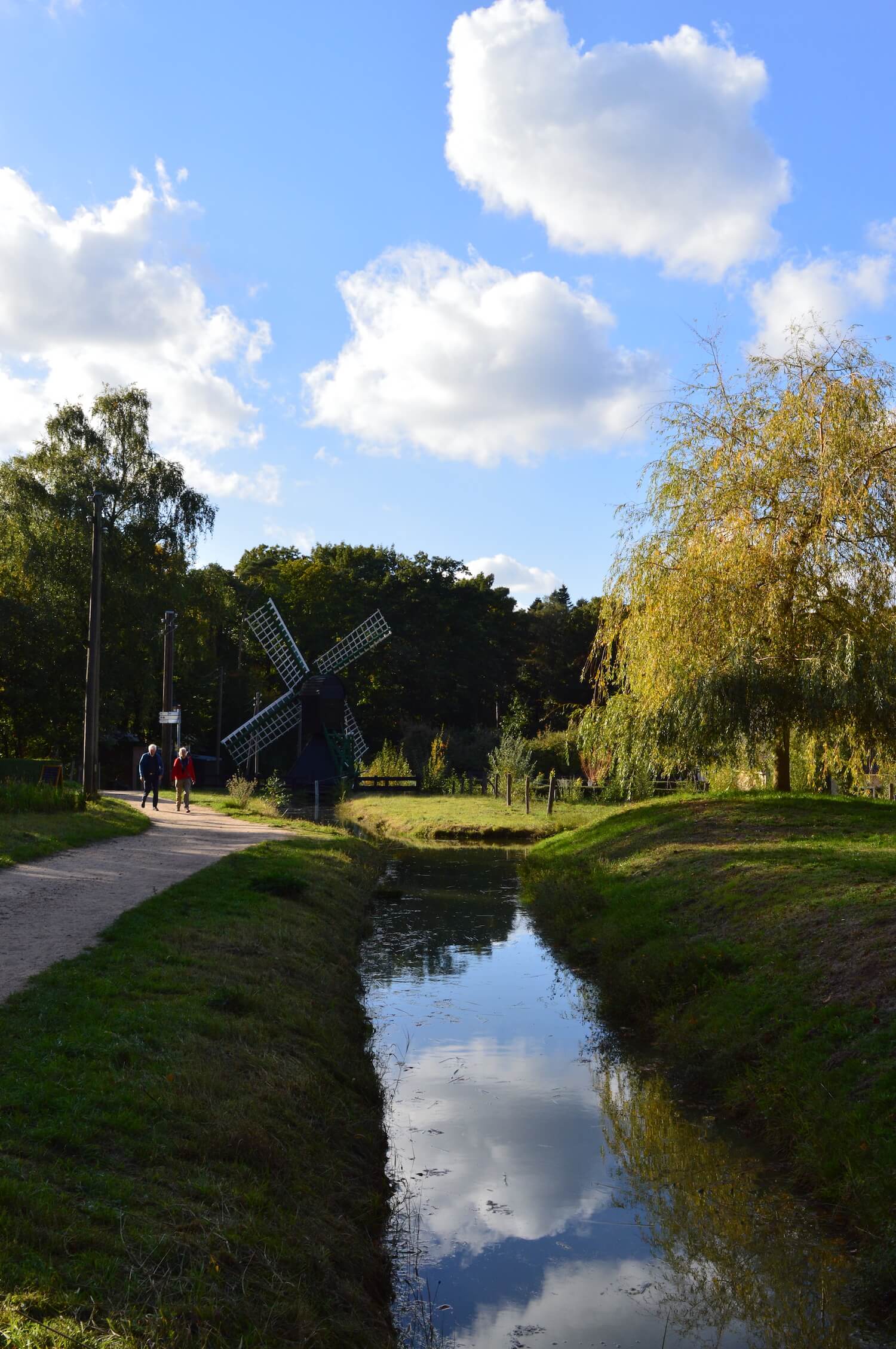 Landscape picture in the open air museum Arnhem, featuring a small canal and a little windmill.
